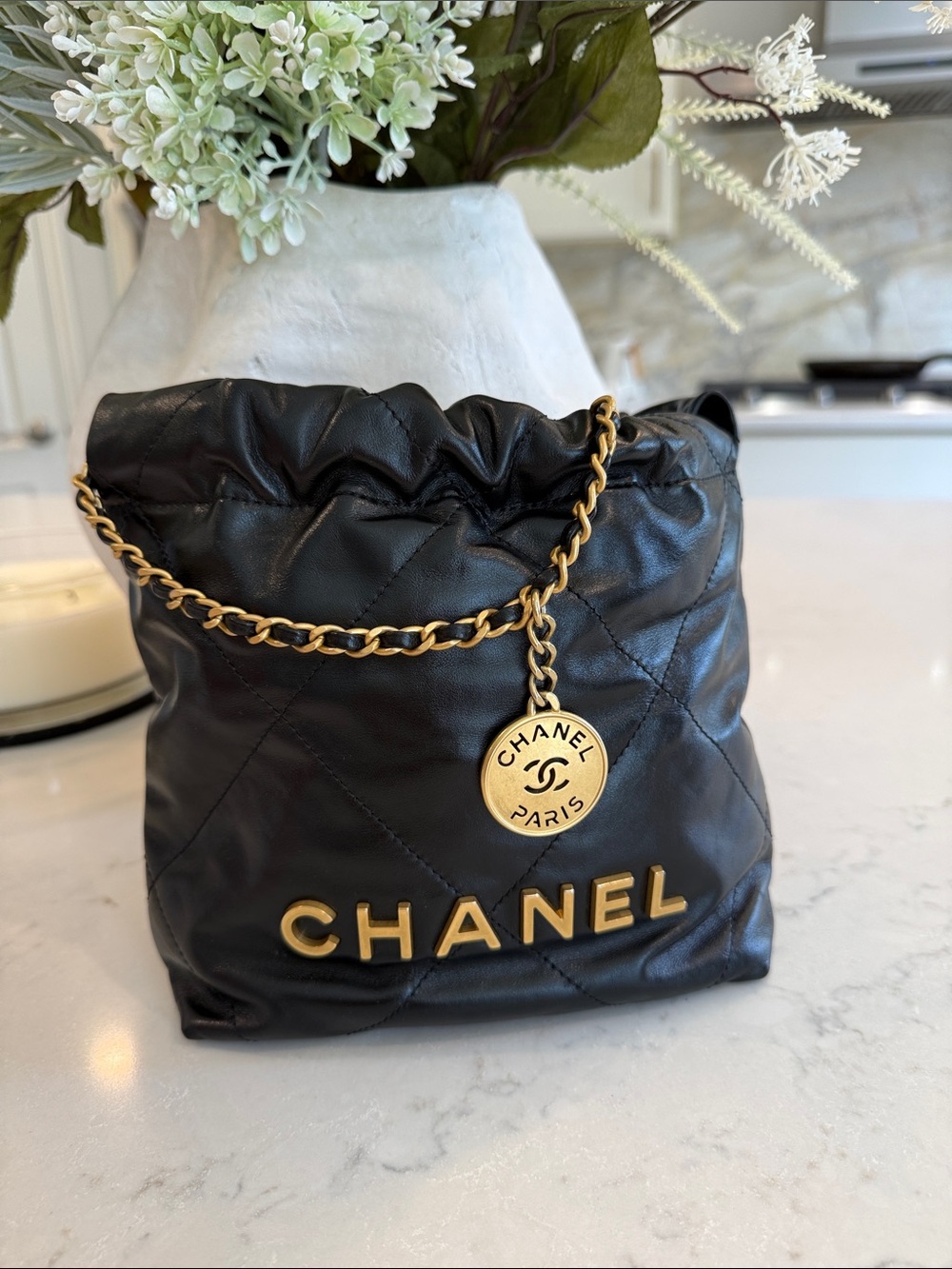 CHANEL 22 Mini Black Quilted Leather Drawstring Crossbody with Gold Logo Charm
